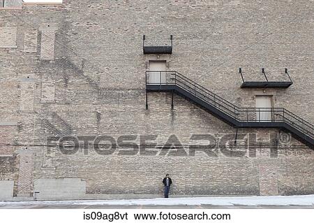Scaled shot of young man in front of large industrial building View Large Photo Image Stock Photograph - Scaled shot of young man in front of large industrial building. Fotosearch
