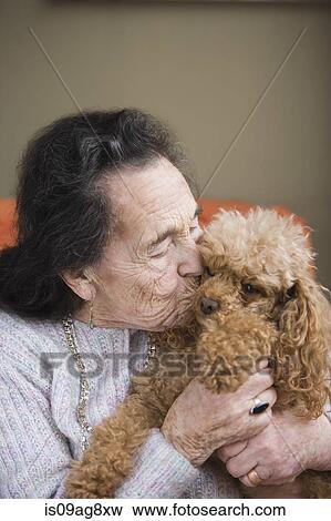 Stock Photo - Senior woman kissing dog. Fotosearch
