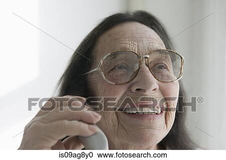 Stock Image - Senior woman wearing glasses on the phone. Fotosearch