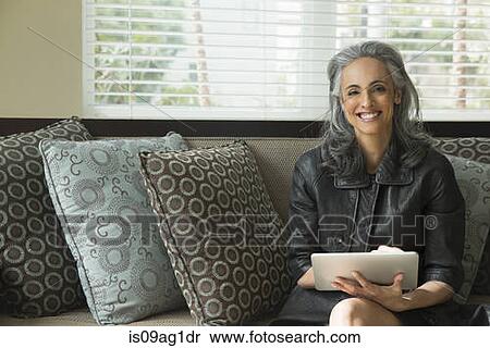 Woman using digital tablet on sofa View Large Photo Image Stock Photography - Woman using digital tablet on sofa. Fotosearch
