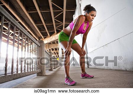 Young female runner taking a break on urban bridge View Large Photo Image Picture - Young female runner taking a break on urban bridge. Fotosearch