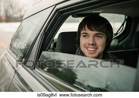 Young man looking out of car window View Large Photo Image Stock Image - Young man looking out of car window. Fotosearch