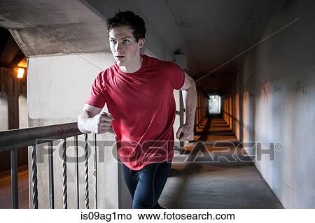 Young man running on city bridge View Large Photo Image Picture - Young man running on city bridge. Fotosearch