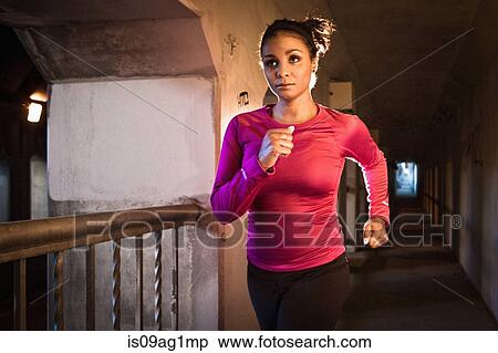 Stock Photography - Young woman running on city bridge. Fotosearch