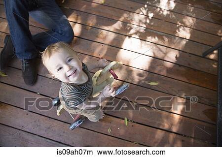 Picture - Baby riding on toy horse. Fotosearch