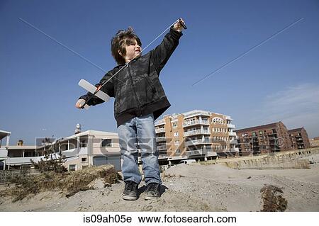 Boy at the coast preparing to fly toy airplane, Long Beach, New York State, USA View Large Photo Image Stock Image - Boy at the coast preparing to fly toy airplane, Long Beach, New York State, USA. Fotosearch
