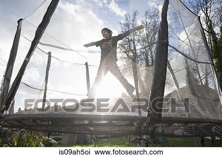 Boy jumping on outdoor trampoline View Large Photo Image Stock Image - Boy jumping on outdoor trampoline. Fotosearch