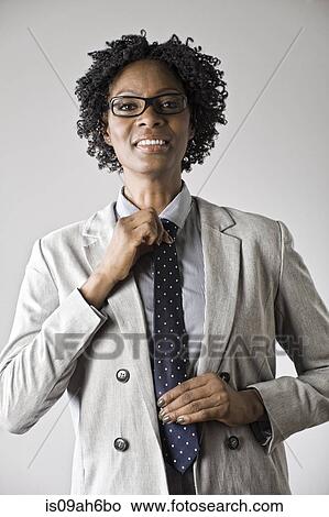 Businesswoman putting on tie View Large Photo Image Picture - Businesswoman putting on tie. Fotosearch