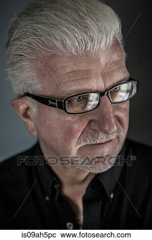 Stock Image - Close up of thoughtful senior man wearing spectacles. Fotosearch