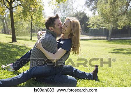 Couple hugging and kissing on grass View Large Photo Image Stock Image - Couple hugging and kissing on grass. Fotosearch