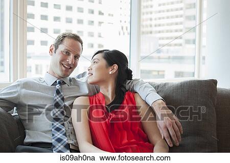 Couple relaxing on sofa View Large Photo Image Stock Image - Couple relaxing on sofa. Fotosearch