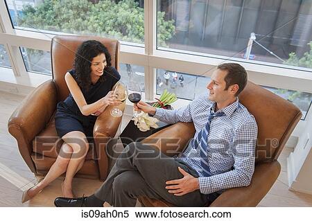 Couple relaxing with a glass of wine at home View Large Photo Image Stock Photography - Couple relaxing with a glass of wine at home. Fotosearch