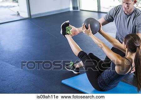 Stock Image - Couple working out with medicine ball. Fotosearch