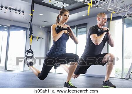 Stock Image - Couple working out with weights. Fotosearch