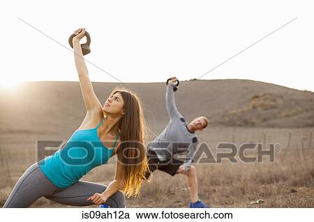 Stock Image - Couple working out with weights. Fotosearch