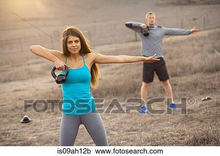 Stock Image - Couple working out with weights. Fotosearch