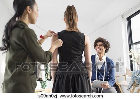 Fashion designer pinning woman's dress View Large Photo Image Stock Image - Fashion designer pinning woman's dress. Fotosearch