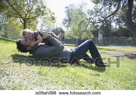 Father and son playing on grass View Large Photo Image Stock Photo - Father and son playing on grass. Fotosearch
