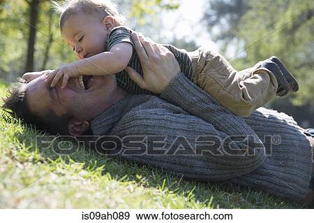 Father and son playing on grass View Large Photo Image Stock Photo - Father and son playing on grass. Fotosearch
