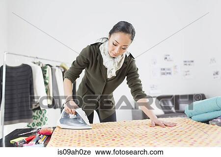 Female fashion designer ironing fabric View Large Photo Image Stock Image - Female fashion designer ironing fabric. Fotosearch
