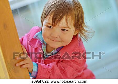 Female toddler peeking from a wooden post View Large Photo Image Stock Photo - Female toddler peeking from a wooden post. Fotosearch