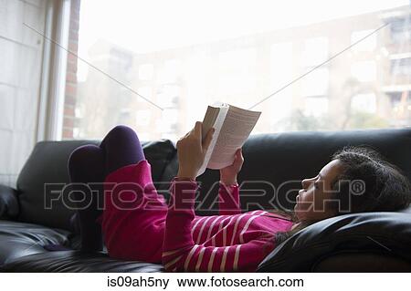Girl lying on sofa, reading book View Large Photo Image Stock Photo - Girl lying on sofa, reading book. Fotosearch