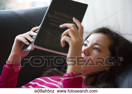 Girl lying on sofa, reading book View Large Photo Image Stock Photo - Girl lying on sofa, reading book. Fotosearch