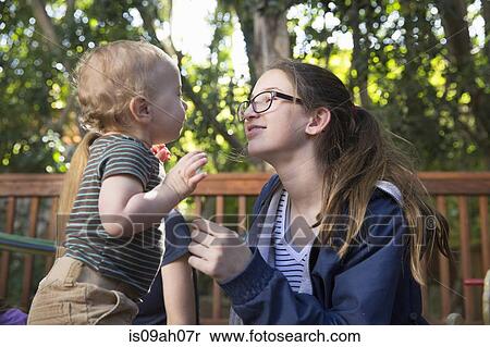 Girl playing with baby brother outdoors View Large Photo Image Stock Photography - Girl playing with baby brother outdoors. Fotosearch