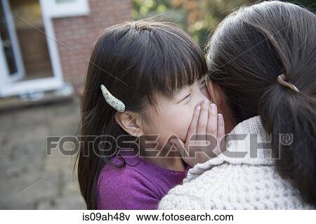 Girl whispering to her mother in the garden View Large Photo Image Stock Photo - Girl whispering to her mother in the garden. Fotosearch