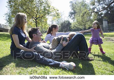 Stock Image - Happy family relaxing on grass. Fotosearch