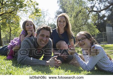 Stock Image - Happy family relaxing on grass. Fotosearch