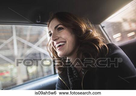 Happy young woman in back seat of taxi View Large Photo Image Stock Photograph - Happy young woman in back seat of taxi. Fotosearch