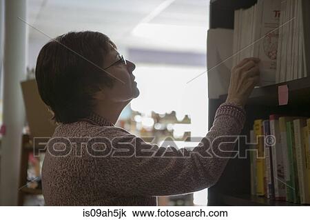 Health food store owner arranging books View Large Photo Image Stock Image - Health food store owner arranging books. Fotosearch
