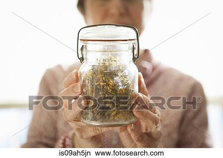 Health foods store owner holding jar of St John's Wort View Large Photo Image Picture - Health foods store owner holding jar of St John's Wort. Fotosearch
