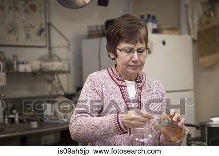 Health foods store owner putting herbs in jars View Large Photo Image Stock Photography - Health foods store owner putting herbs in jars. Fotosearch