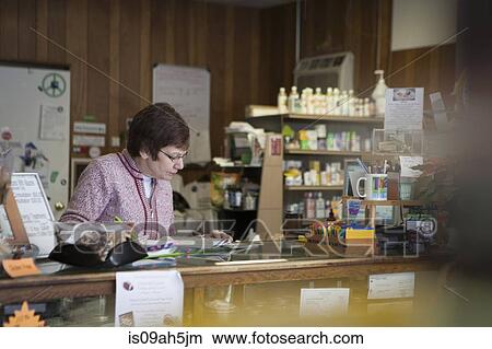 Health foods store owner working at counter View Large Photo Image Picture - Health foods store owner working at counter. Fotosearch