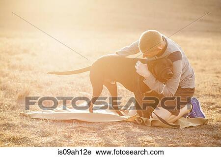 Stock Image - Man hugging dog. Fotosearch