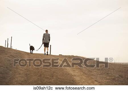 Stock Image - Man walking dog. Fotosearch