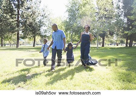 Mature couple with son and daughter strolling in park View Large Photo Image Stock Photo - Mature couple with son and daughter strolling in park. Fotosearch