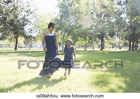 Mature woman and daughter strolling in park View Large Photo Image Stock Photograph - Mature woman and daughter strolling in park. Fotosearch