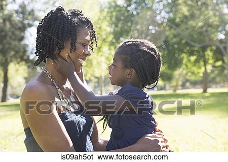 Mature woman carrying affectionate daughter in park View Large Photo Image Stock Photograph - Mature woman carrying affectionate daughter in park. Fotosearch