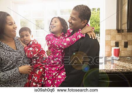 Mid adult couple and children in kitchen View Large Photo Image Stock Photograph - Mid adult couple and children in kitchen. Fotosearch