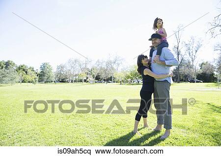 Mid adult couple enjoying the park with young daughter View Large Photo Image Stock Photography - Mid adult couple enjoying the park with young daughter. Fotosearch