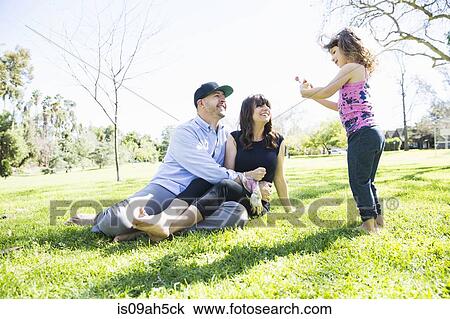 Mid adult couple in the park with young daughter View Large Photo Image Stock Image - Mid adult couple in the park with young daughter. Fotosearch