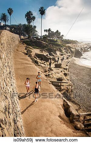 Mid adult women jogging along cliff View Large Photo Image Stock Image - Mid adult women jogging along cliff. Fotosearch