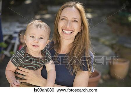 Mother carrying baby in garden View Large Photo Image Stock Image - Mother carrying baby in garden. Fotosearch
