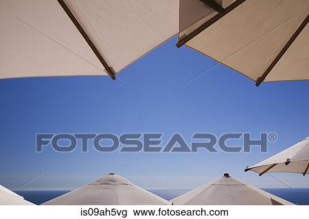 Stock Image - Parasols with clear blue sky and sea. Fotosearch