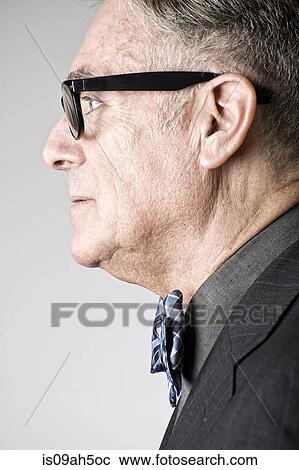 Stock Image - Portrait of senior man wearing bowtie, side view. Fotosearch