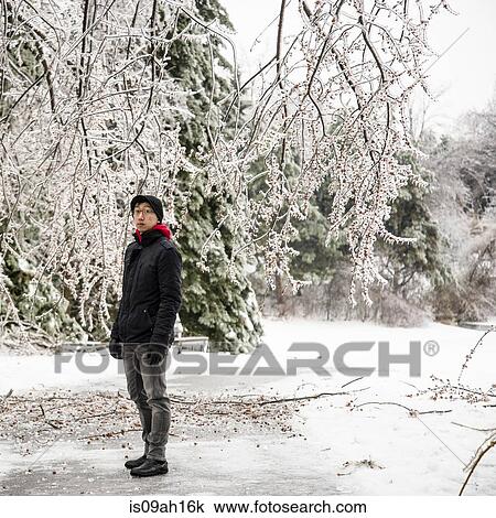 Stock Image - Portrait of young man standing in park at -30 degrees celcius. Fotosearch