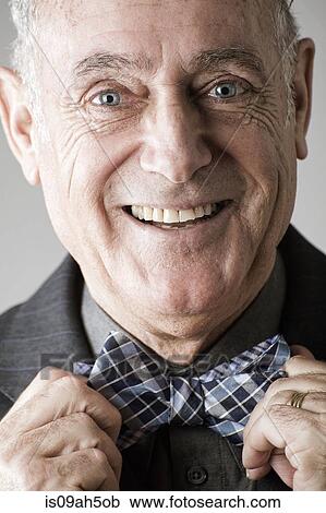 Senior man putting on bow tie View Large Photo Image Stock Image - Senior man putting on bow tie. Fotosearch